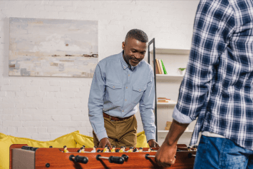 An adult father and son happy playing foosball