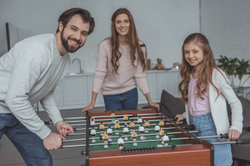 A young family playing foosball