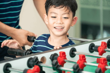 Closeup of a child and a foosball table