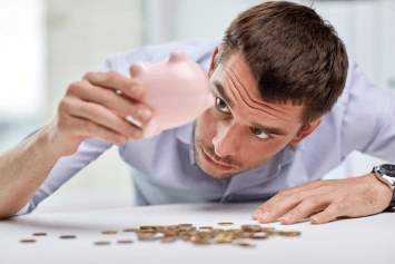 A man raiding his piggy bank for money